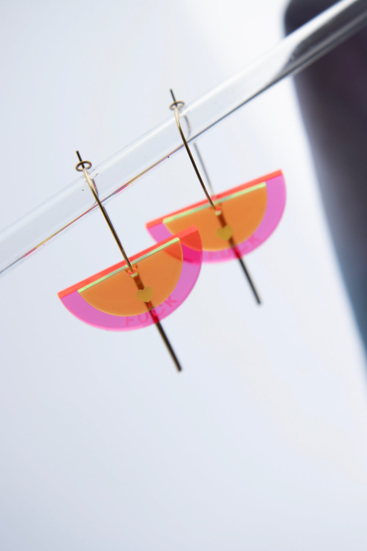 Gold-colored "FUCK" neon acrylic hoop earrings